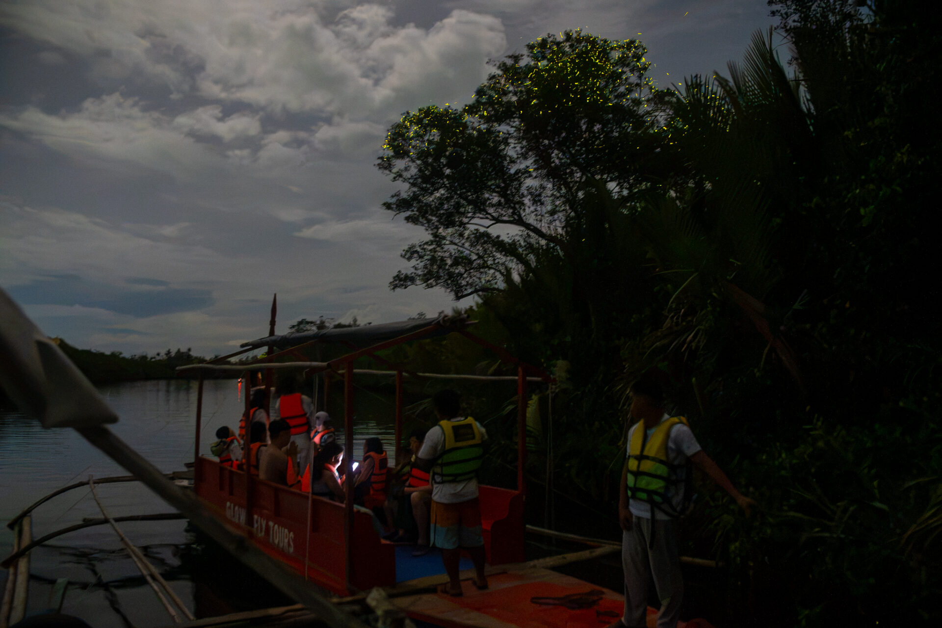 Visitors boarding a traditional boat for the Abatan Community Life Tour and firefly watching experience in Bohol Island Geopark.