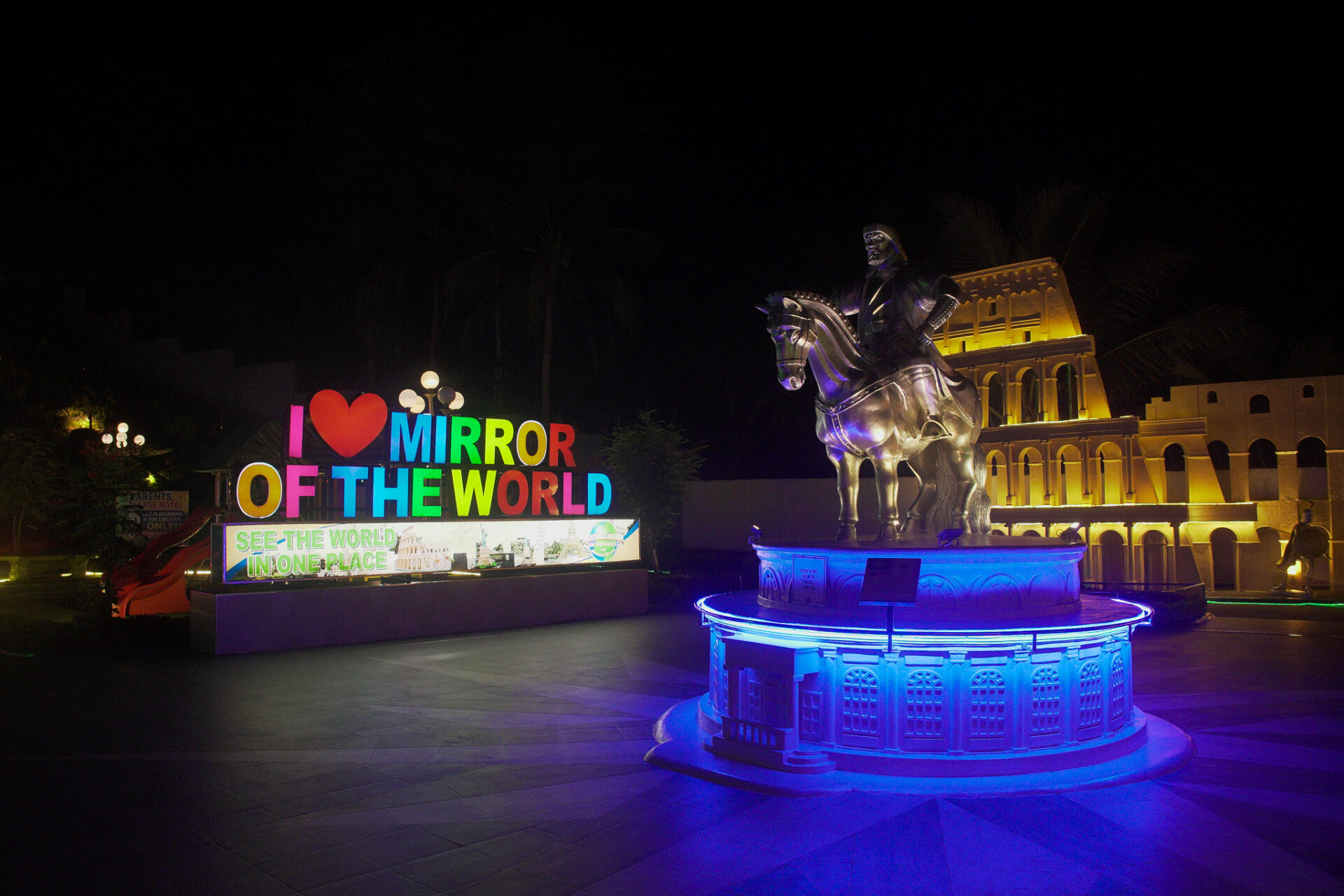Illuminated Mirror of the World attraction in Panglao, Bohol featuring colorful lights and world landmark replicas at night.