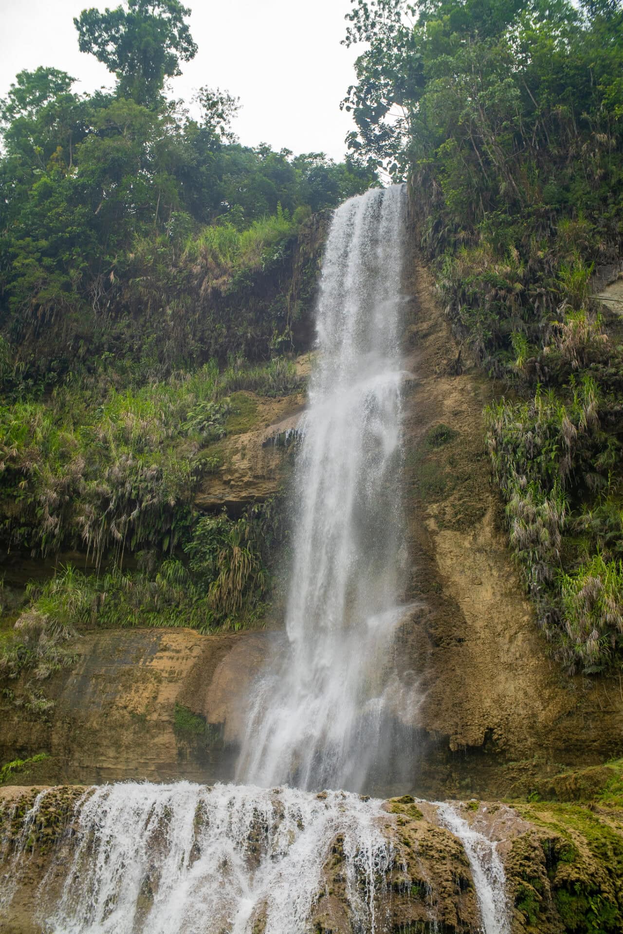 Towering Can-Umantad Falls cascading through lush tropical forest in Candijay, Bohol Island Geopark.