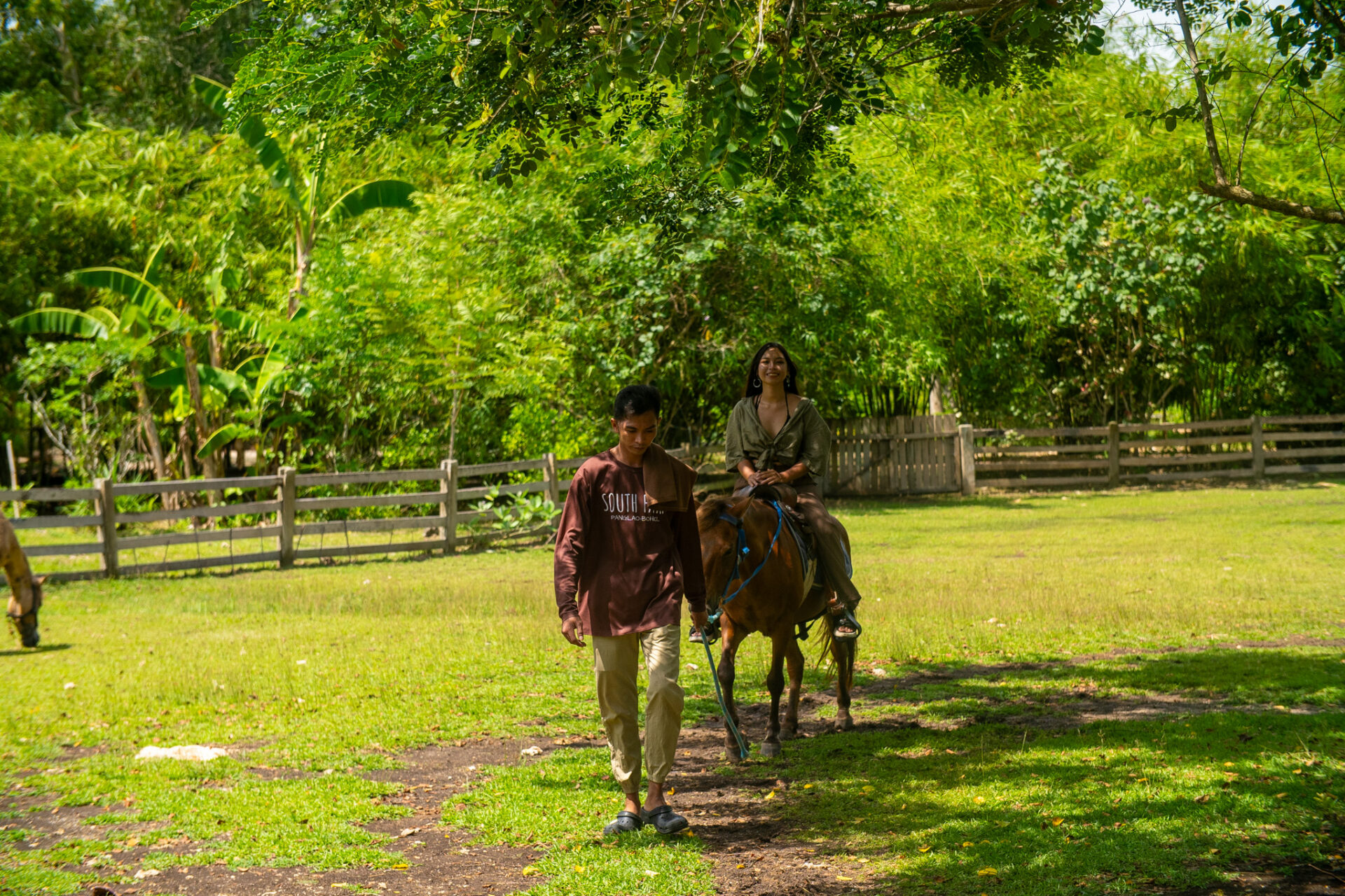 Visitor enjoying a horseback riding experience at South Farm Panglao surrounded by lush tropical gardens in Bohol, Philippines.