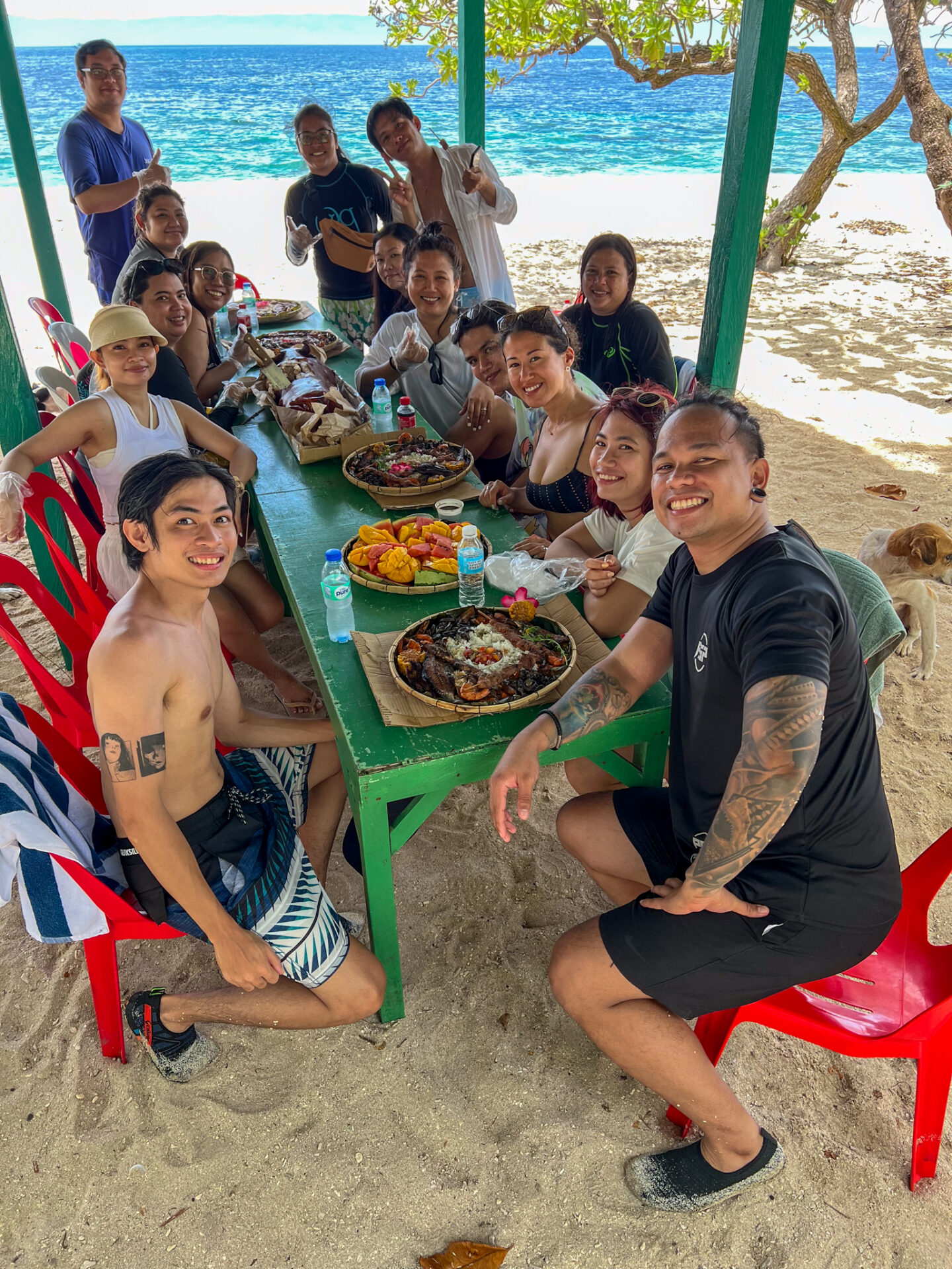 Travelers enjoying a fresh seafood boodle feast at a beachside cottage on Balicasag Island during an island hopping experience in Bohol Island Geopark.
